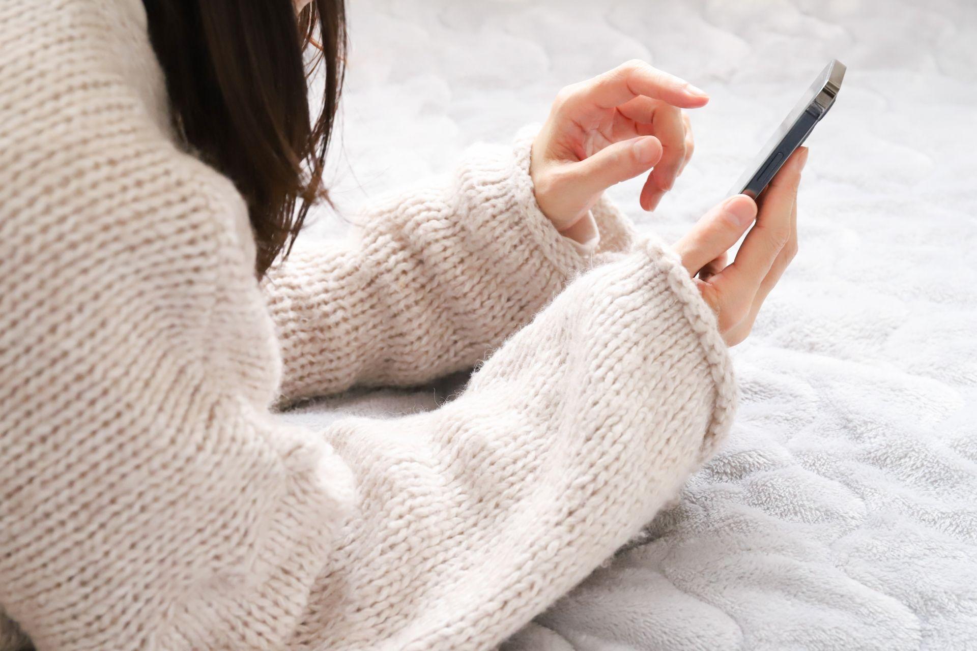 スマートフォンでクリニック探しをする女性