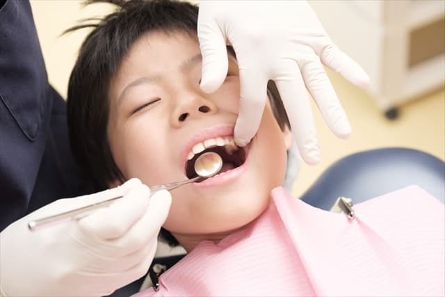 歯医者で診察を受ける子供