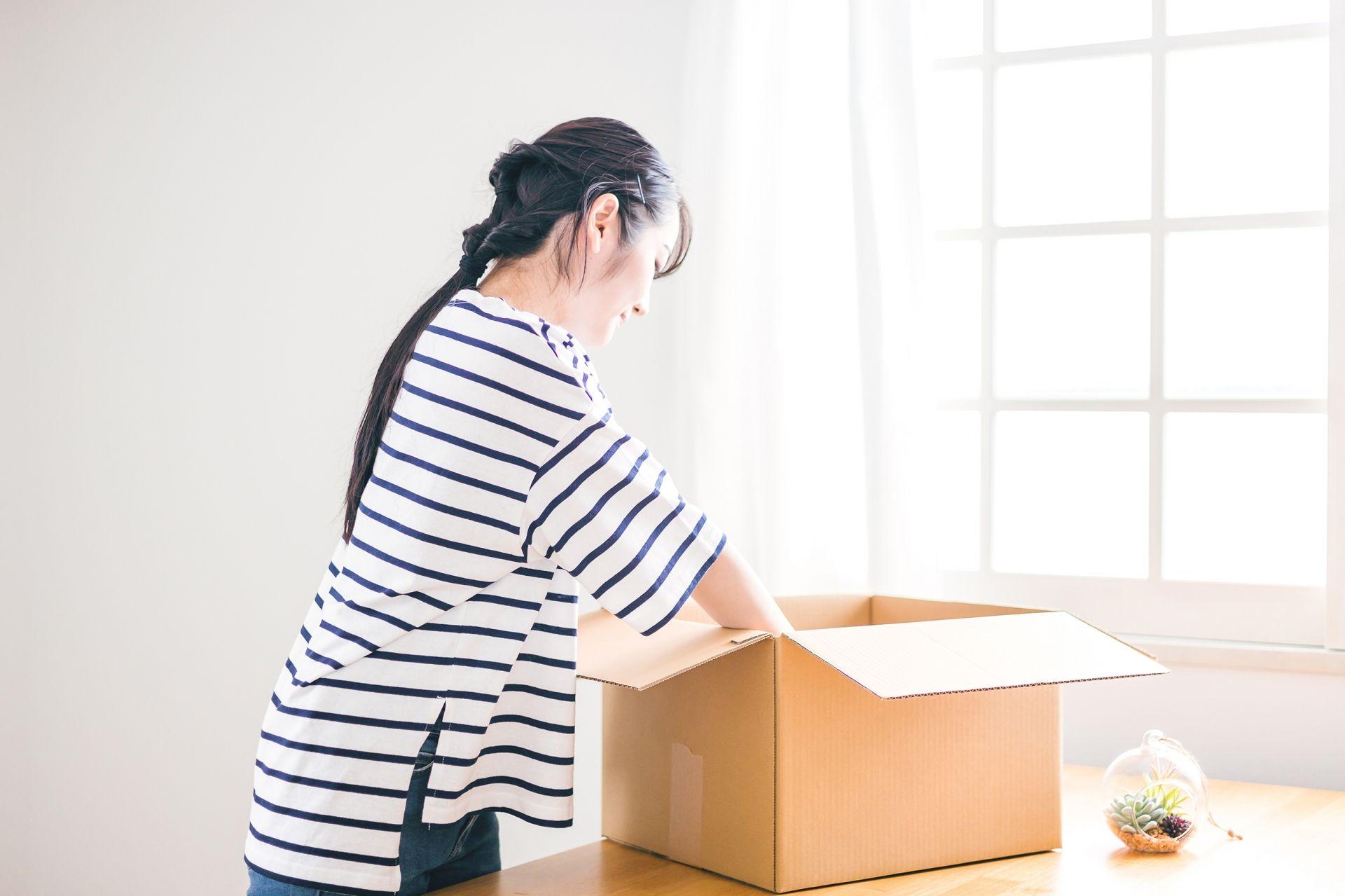 引っ越しのための荷造りをする女性