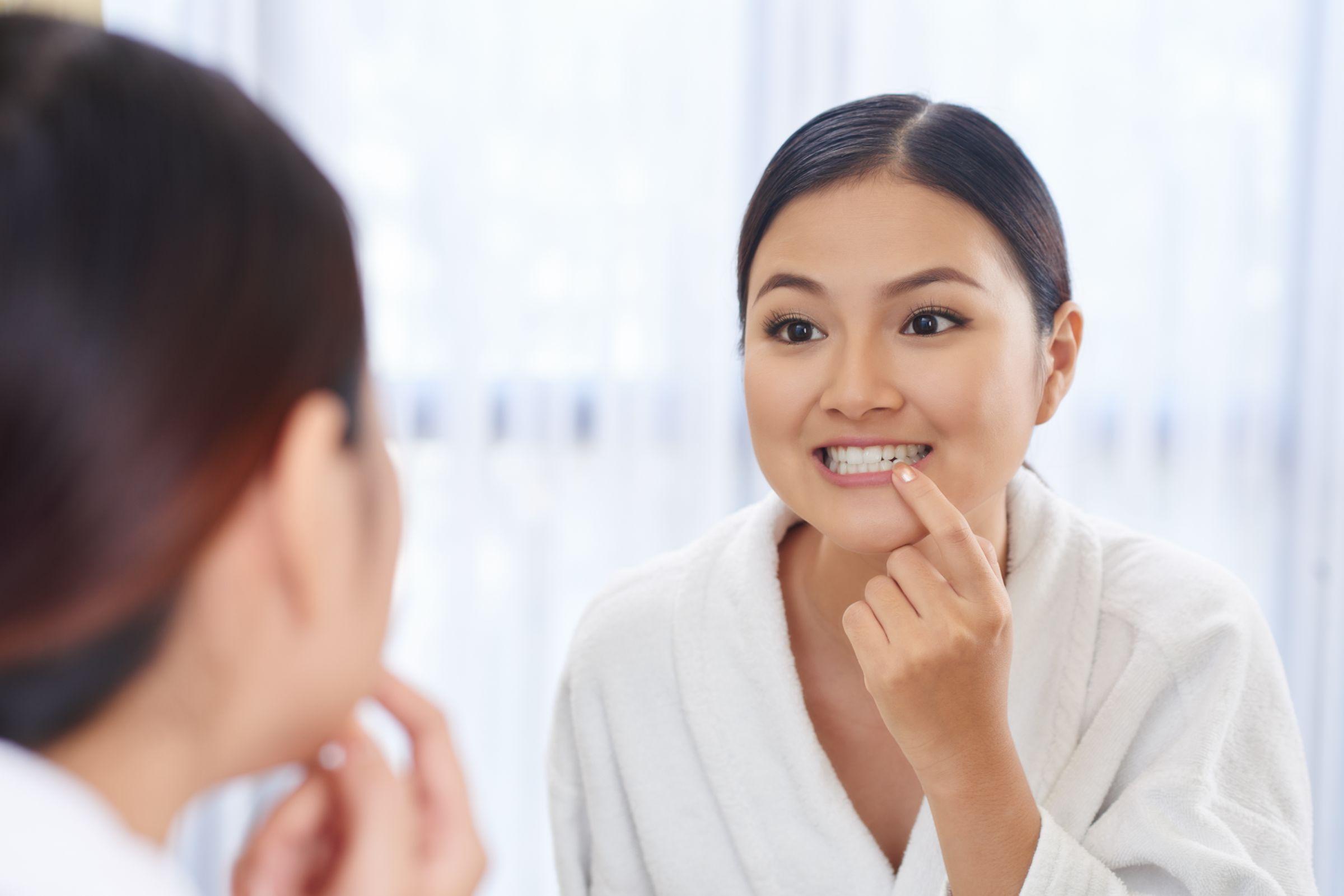 自分の白い歯を鏡で見る女性